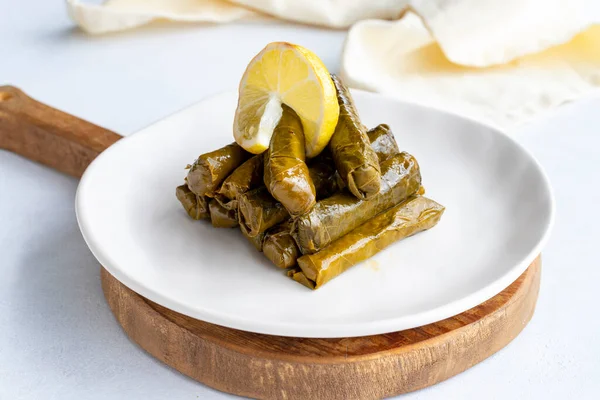 Stuffed leaves with olive oil on a white background. The traditional taste of Turkish cuisine. Local name zeytinyagli yaprak sarma