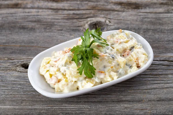Geleneksel Rus salatası ve fırında sebze ve mayonez. Ahşap arkaplan.