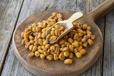 Kızarmış mısır çerezi. Tahta kaşıkta soslu mısır çerezi. toplu mısır ve fındık taneleri.