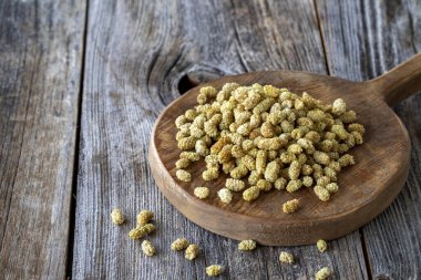 Kurutulmuş dut. Ahşap arka planda kurutulmuş dut fıstığı. Kurutulmuş dut taneleri. Boşluğu kopyala