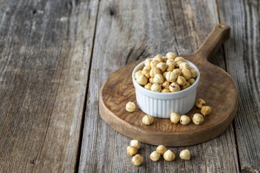 Kavrulmuş fındık. Ahşap arka planda fındık. Toplu fındık çekirdekleri. Seramik tabakta fındık. Boşluğu Kopyala