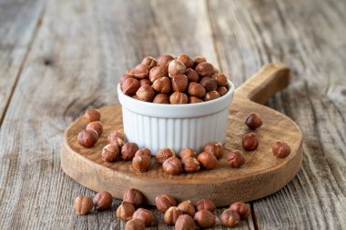 Organik fındık. Ahşap arka planda fındık. Toplu fındık çekirdekleri. Seramik tabakta fındık