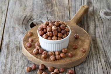 Organik fındık. Ahşap arka planda fındık. Toplu fındık çekirdekleri. Seramik tabakta fındık