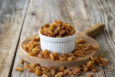 Kuru üzüm. Ahşap zeminde kuru kuru üzümlü fındık. Toplu kuru üzüm taneleri. Seramik tabakta kuru üzüm