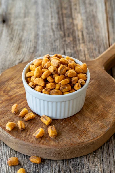 Kızarmış mısır çerezi. Ahşap arka planda soslu mısır çerezi. Toplu mısır ve fındık taneleri. Seramik tabakta kavrulmuş mısır fıstığı.