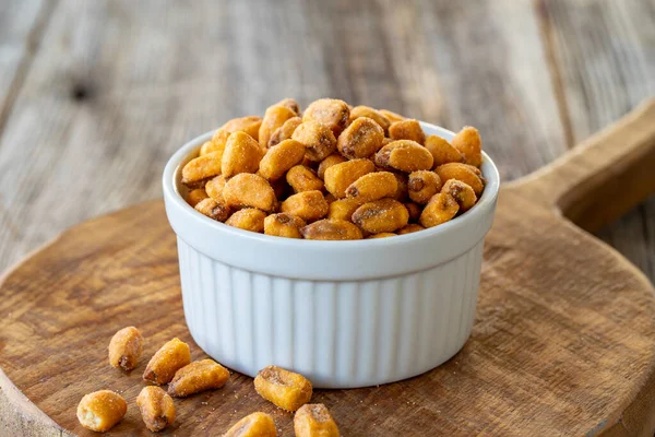 Kızarmış mısır çerezi. Ahşap arka planda soslu mısır çerezi. Toplu mısır ve fındık taneleri. Seramik tabakta kavrulmuş mısır fıstığı.