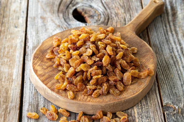 Kuru üzüm. Ahşap zeminde kuru kuru üzümler. Toplu kuru üzüm taneleri