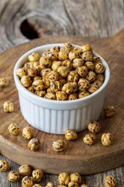 Kızarmış nohut. Ahşap zeminde nohut fıstığı. Nohut taneleri. Seramik tabakta nohut