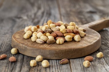 Ahşap zeminde karışık fındık. Organik ve taze fındık. Kapat.