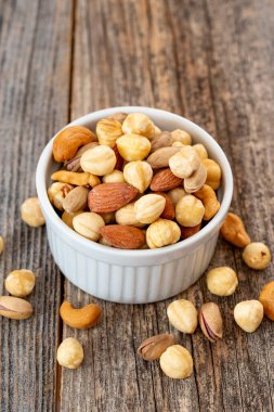 Seramik tabakta karışık fındık. Organik ve taze fındık. Kapat.