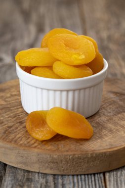 Tabakta kurutulmuş kayısı. Ahşap zeminde kurumuş kayısılar. Organik ve taze fındık. Kapat.