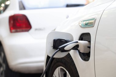 Elektrikli araba şarjı için güç kaynağı. Elektrikli araba şarj istasyonu. Şarj olan bir elektrikli arabaya takılan güç kaynağını kapatın. araba eklentisi hibrit.