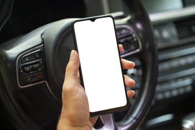 Araba kullanırken navigatör kullandığı elinde boş ekranla cep telefonu tutan genç adamın yakın çekimi. Model telefon