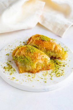 Beyaz ahşap arka planda fıstıklı sobiyet baklavası. Mermer zeminde Baklava.
