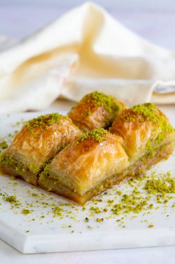 Beyaz ahşap arka planda fıstıklı baklava. Mermer zeminde baklava. Kapat.