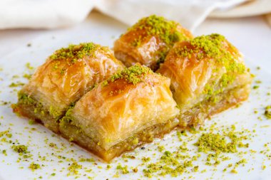 Beyaz ahşap arka planda fıstıklı baklava. Mermer zeminde baklava. Kapat.