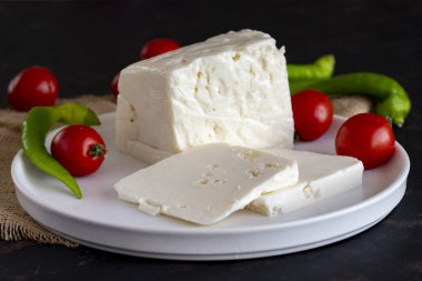 Koyu arkaplanda dilimlenmiş peynir.