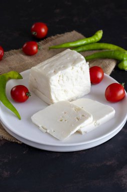 Koyu arkaplanda dilimlenmiş peynir.