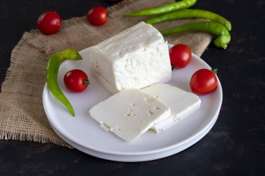 Koyu arkaplanda dilimlenmiş peynir.