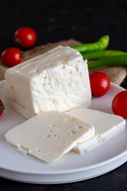 Koyu arkaplanda dilimlenmiş peynir.