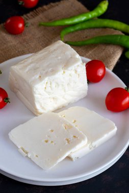 Koyu arkaplanda dilimlenmiş peynir.