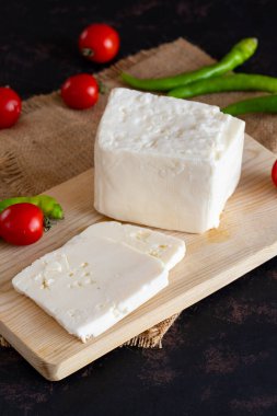 Koyu arkaplanda dilimlenmiş peynir.