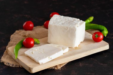 Koyu arkaplanda dilimlenmiş peynir.