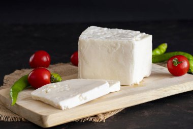 Koyu arkaplanda dilimlenmiş peynir.