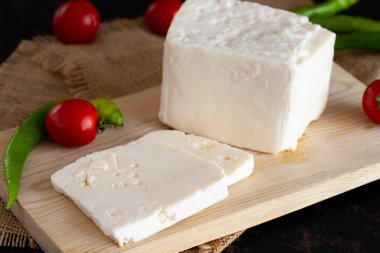 Koyu arkaplanda dilimlenmiş peynir.