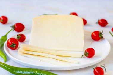 Beyaz tabakta bayat çedar peyniri. Dilimlenmiş Cheddar Gruyere Cheddar. yerel adı gravyer peynir