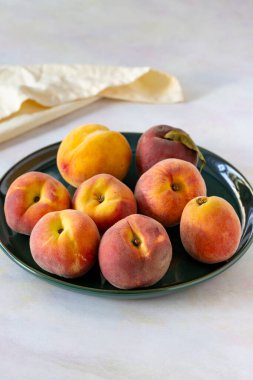 Yeşil seramik tabakta olgun taze şeftaliler