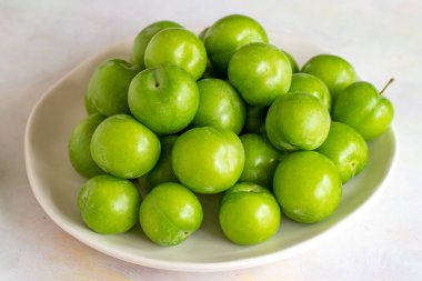 Beyaz arkaplanda yeşil erik.