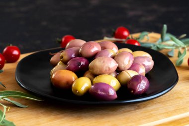 Karışık zeytin (yeşil ve mor). Tabakta lezzetli renkli zeytinler.