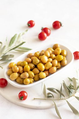 Sarı zeytinler çizilmiş. Tabakta lezzetli organik sarı zeytinler var. Mermer zeminde zeytin