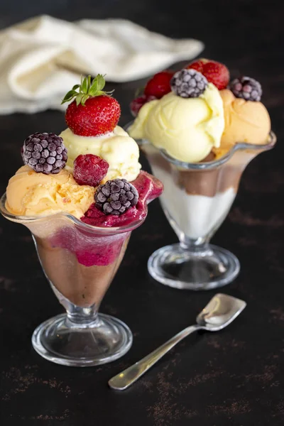 ガラスボウルにアイスクリーム 暗い背景にアイスクリーム ミルク チョコレート チェリー メロン キャラメルアイスクリーム — ストック写真