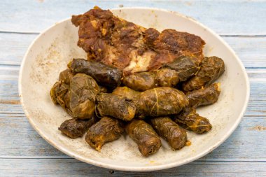 Et yaprağı ambalajı. Geleneksel Akdeniz aroması. Mavi ahşap arka planda yaprakları sarıyor. yerel adı etli yaprak sarma