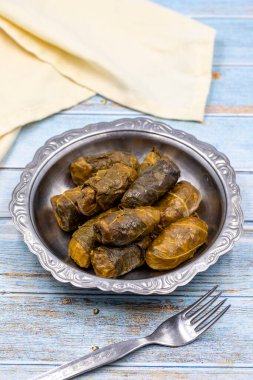Et yaprağı ambalajı. Geleneksel Akdeniz aroması. Mavi arka planda yoğurtlu sarılmış yapraklar. yerel adı etli yaprak sarma