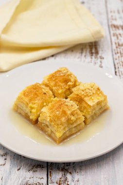 Sütlü Baklava (sutlu nuriye). Beyaz ahşap arka planda fındıklı ve sütlü baklava..
