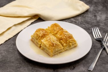 Sütlü Baklava (sutlu nuriye). Fındıklı baklava ve koyu arkaplanda süt..