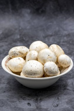 Karanlık bir zeminde seramik bir tabakta mantarlar. Ekilmiş mantar veya portobello mantarı.