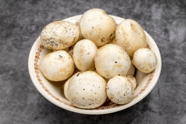 Karanlık bir zeminde seramik bir tabakta mantarlar. Ekilmiş mantar veya portobello mantarı.