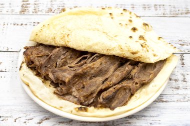 Ahşap bir arka planda döner kebap. Geleneksel Türk mutfağı çeşnili et bağışçısı.