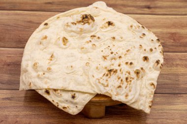 Ahşap zemin üzerinde ev yapımı ekmek (pita, puri, chapati, lavaş ekmeği).