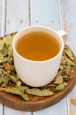 Mavi ahşap arka planda kış bitkisel çayı. Kış çayı. Bağışıklık arttırıcı bitki çayı. Ihlamur yaprakları, karanfil parçacıkları ve papatya çayı.