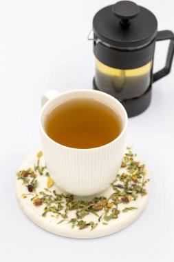 Beyaz arka planda bitki çayını gevşet. Limon yaprağı, yasemin çiçeği, elma kabuğu, portakal, limon ve amber tanecikleriyle hazırlanmış bitki çayı..