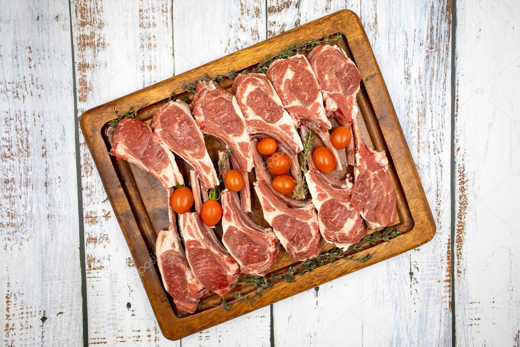 Lamb chops on wooden background. Raw lamb chops on wood serving board. Top view