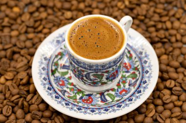 Klasik bir kahve fincanında Türk kahvesi. Kahve çekirdekleri. Kapat.