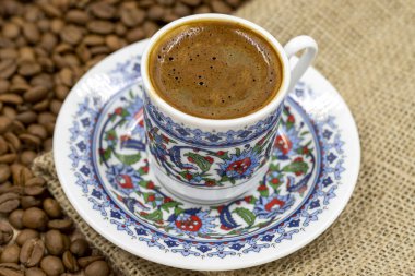 Ahşap zeminde Türk kahvesi. Klasik Türk kahve fincanı. Arkadaki kahve çekirdekleri. Kapat.