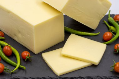 Çedar peyniri ya da beyaz arka planda kaşkaval peyniri. Servis masasında peynir dilimleri