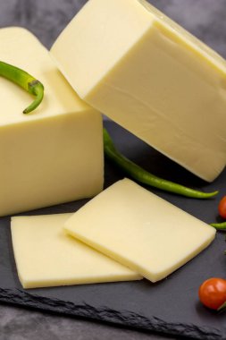 Çedar peyniri ya da koyu arkaplanda kaşkaval peyniri. Servis masasında peynir dilimleri